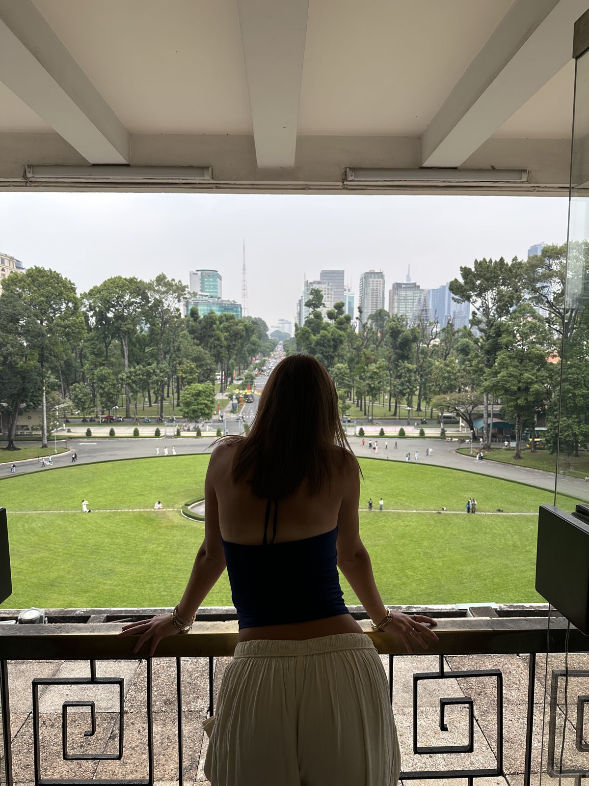 Hannah looking out over a city park from a balcony