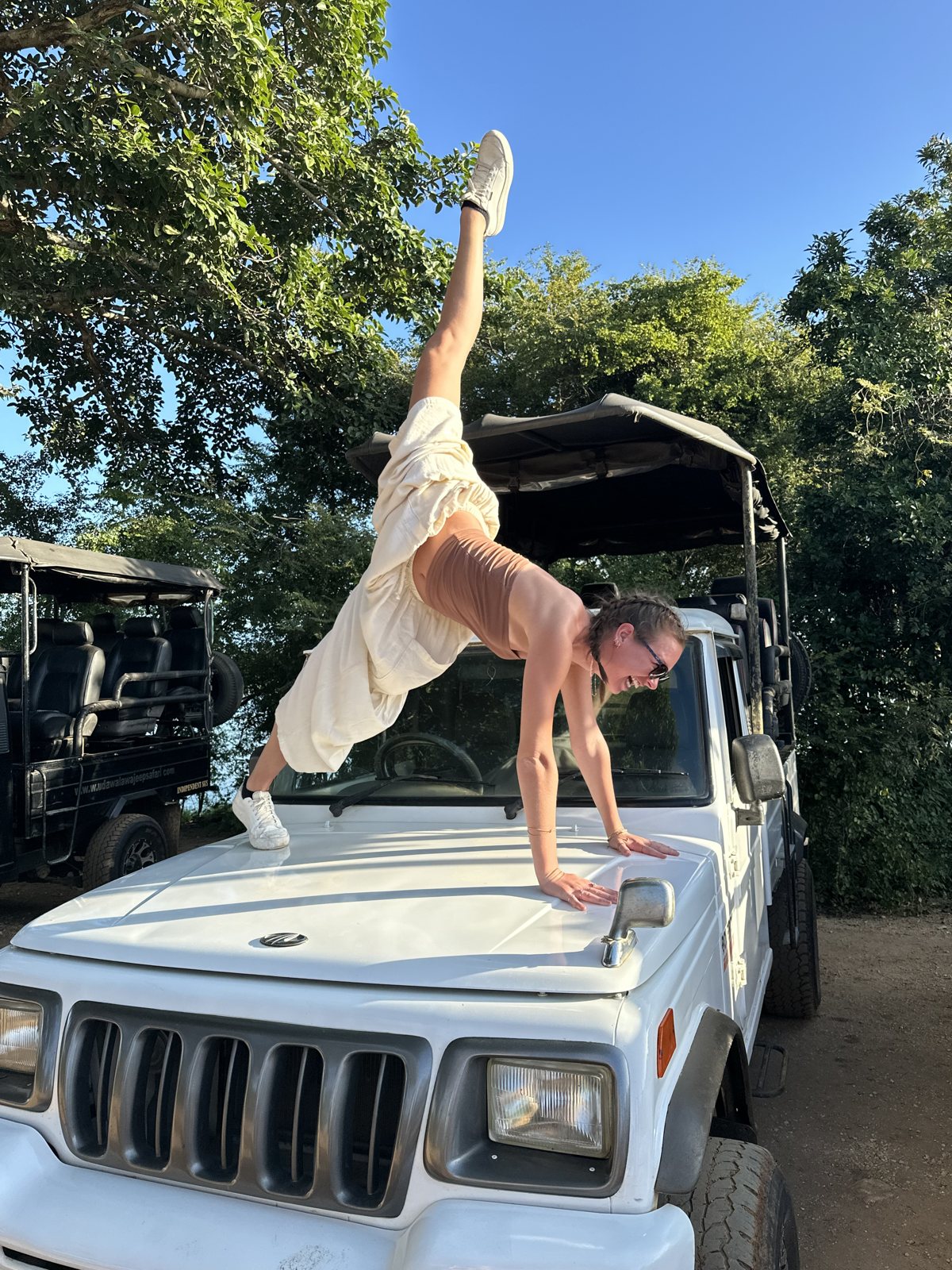 Hannah Pfefferle doing a handstand on the bonnet of a safari jeep
